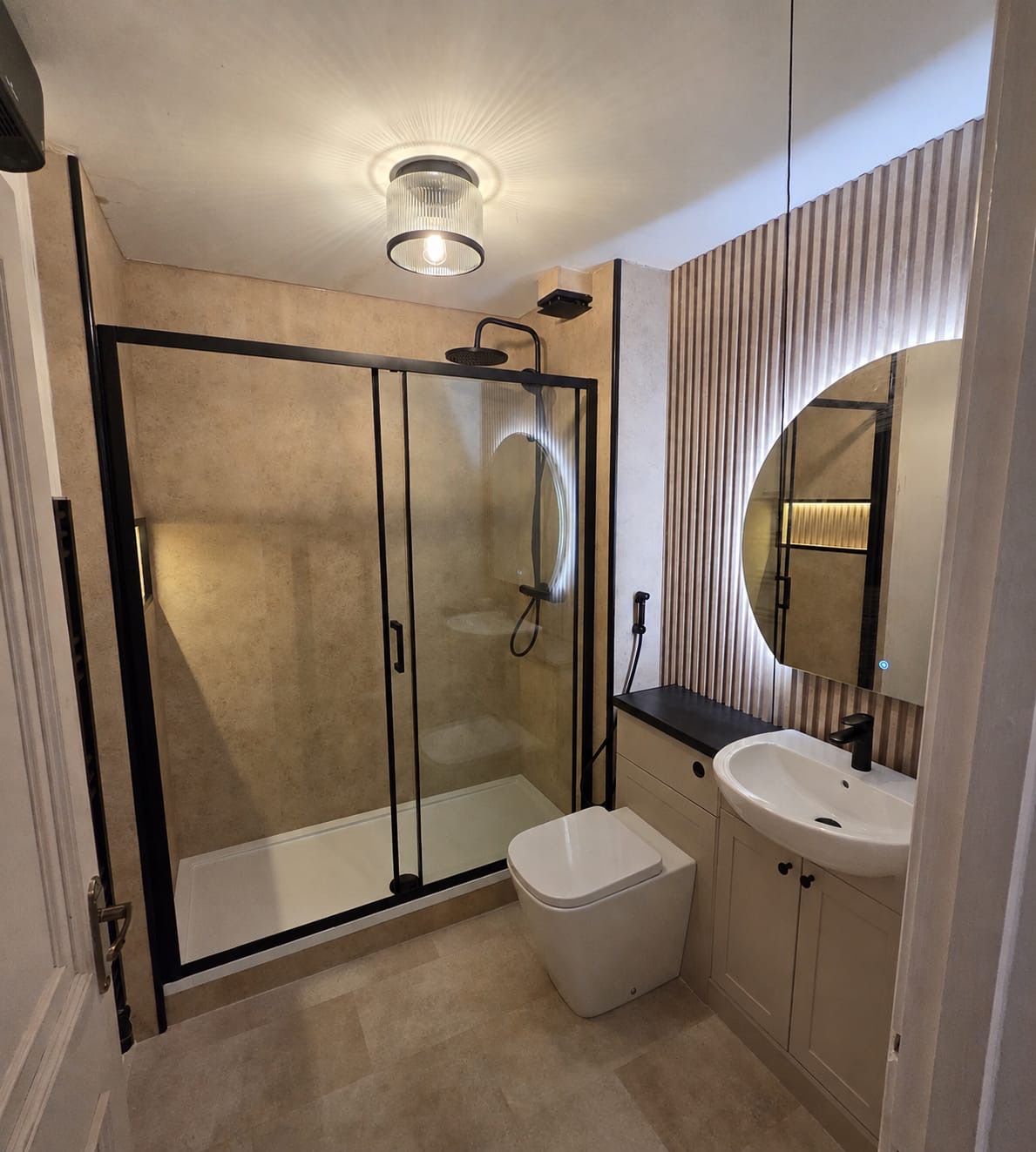 Stone-effect shower room with black framed sliding door and slatted feature wall